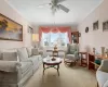 Carpeted living room with an AC wall unit, radiator heating unit, and crown molding