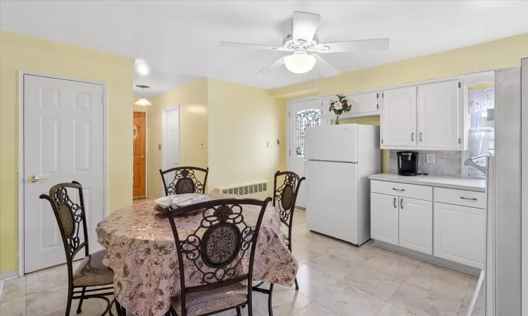 Dining space featuring light tile patterned floors, visible vents, and a ceiling fan