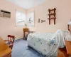 Bedroom featuring a wall unit AC, radiator, baseboards, and carpet flooring