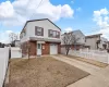 View of front of property with brick siding, roof with shingles, concrete driveway, a garage, and fence private yard