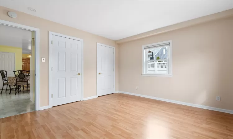 Unfurnished bedroom with light wood-style flooring and baseboards