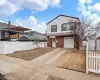 View of front of house featuring an attached garage, brick siding, fence, driveway, and roof with shingles