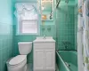 Full bathroom featuring toilet, vanity, shower / bath combination with curtain, and tile walls