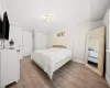 Bedroom with a closet, light hardwood / wood-style flooring, and ornamental molding