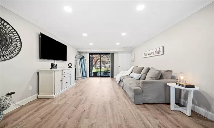 Living room with light hardwood / wood-style flooring and crown molding