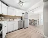 Kitchen with white cabinetry, light wood-type flooring, appliances with stainless steel finishes, and sink