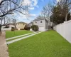 View of yard with concrete driveway, an attached garage, and fence