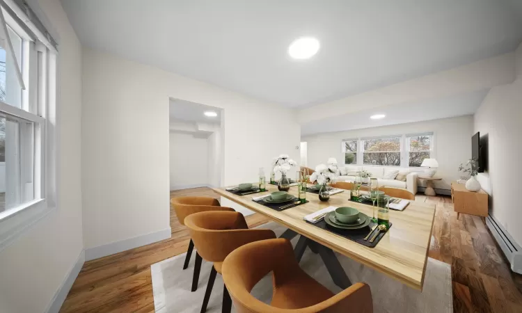 Dining space with recessed lighting, a baseboard radiator, a baseboard heating unit, wood finished floors, and baseboards