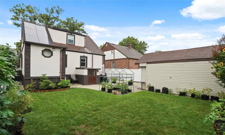 Back of house featuring fence, a yard, roof with shingles, stucco siding, and a patio area