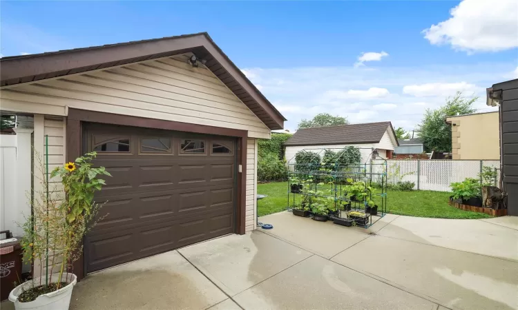 Detached garage with fence and concrete driveway