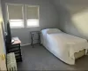 Carpeted bedroom featuring radiator heating unit and vaulted ceiling