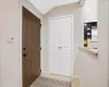 Foyer entrance with vaulted ceiling, light tile patterned floors, and baseboards