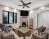 Living area featuring a warm lit fireplace, a baseboard radiator, recessed lighting, wood finished floors, and visible vents