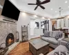 Living room featuring recessed lighting, dark wood-type flooring, visible vents, baseboards, and a glass covered fireplace