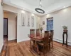 Dining room featuring baseboards, visible vents, wood finished floors, a tray ceiling, and recessed lighting