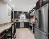 Kitchen with high end appliances, decorative backsplash, dark brown cabinets, under cabinet range hood, and a sink