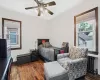 Bedroom featuring a ceiling fan, radiator, baseboards, and wood finished floors