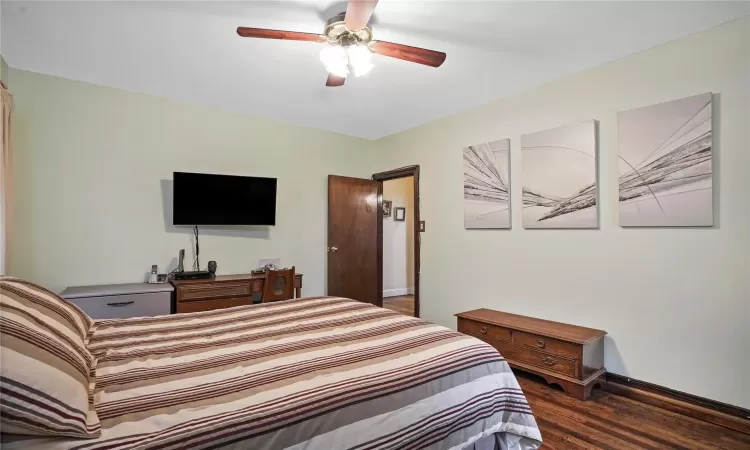 Bedroom featuring baseboards, a ceiling fan, and wood finished floors