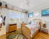 Bedroom 4 featuring a raised shelf, a fixed oval shaped window and plenty of large windows facing the lighthouse and a ceiling fan with light