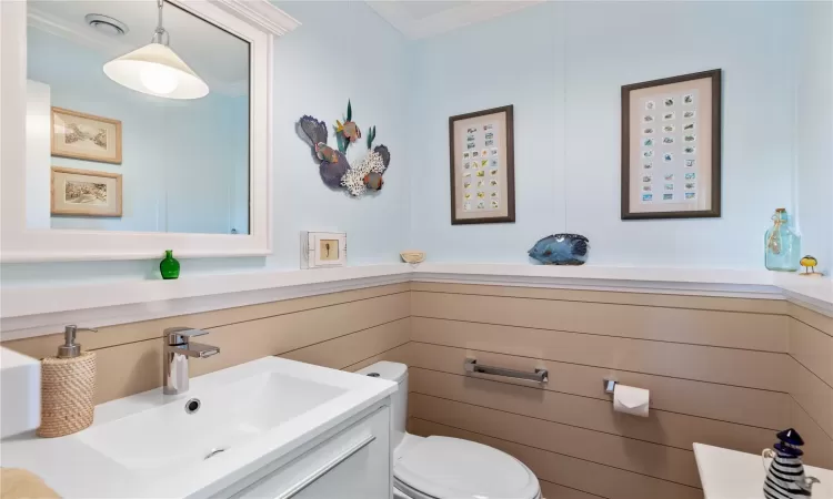 Half Bathroom (1st Floor) featuring ornamental molding, vanity, and toilet