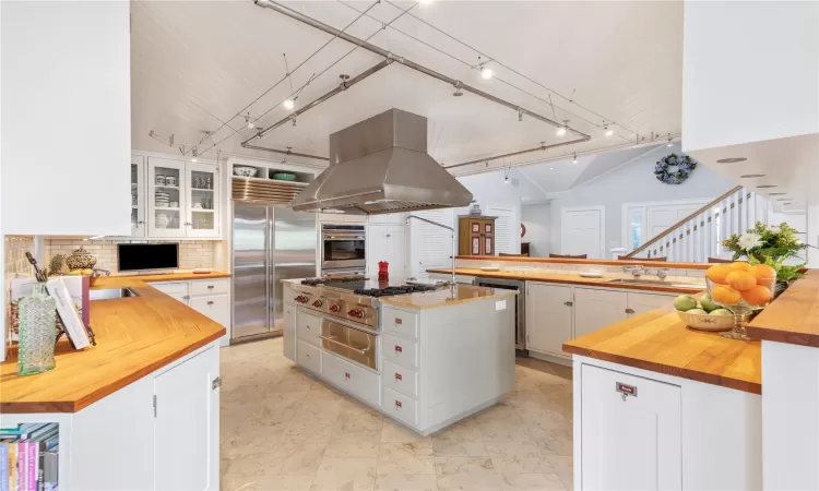 Wolf Gas Grill W/ Wolf Exhaust Hood, Warming Drawer, Labeled cabinet pulls, and exposed stainless steel fire sprinkler system. Beaded tongue in groove ceiling