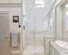 Bathroom featuring a smart shower, skylights, and towel warmer, separate toilet room