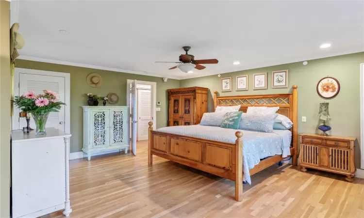 Primary Bedroom featuring ornamental crown moulding, ceiling fan, light wood finished floors, and recessed lighting