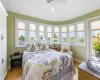 Bedroom 2, ensuite with access to exterior second floor deck, multiple windows, and hardwood floors