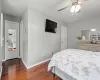 Bedroom with ceiling fan, dark wood finished floors, and baseboards