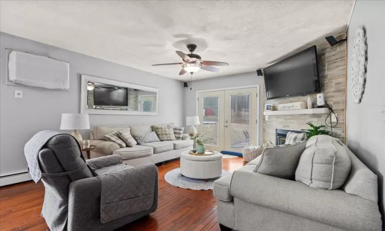 Living room with ceiling fan, french doors, hardwood / wood-style floors, and a textured ceiling