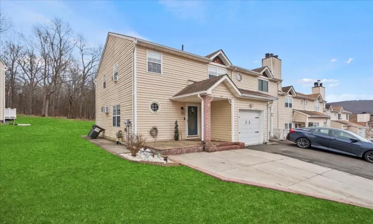 Multi unit property featuring a front lawn and aphalt driveway