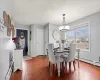 Dining room featuring a baseboard heating unit, a textured ceiling, dark wood-style floors, and an inviting chandelier