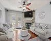 Living area with french doors, a fireplace, wood-type flooring, ceiling fan, and a textured ceiling