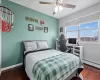 Bedroom featuring baseboard heating, ceiling fan, a textured ceiling, wood finished floors, and baseboards