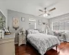 Bedroom with baseboards, ceiling fan, a baseboard heating unit, and dark wood-style flooring