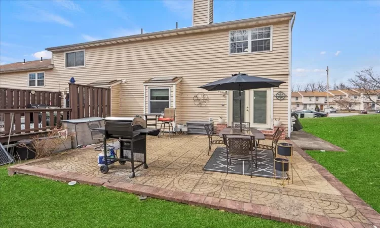 Back of house with a patio, a yard, and a chimney