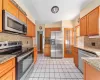 Kitchen featuring stainless steel appliances, light stone countertops, backsplash, and light tile patterned floors