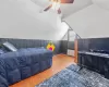 Bedroom featuring radiator heating unit, wooden walls, vaulted ceiling, and wood finished floors