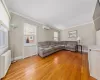 Unfurnished living room featuring light wood-style floors, an AC wall unit, a healthy amount of sunlight, and radiator heating unit