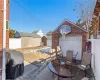 View of patio / terrace featuring an outbuilding, outdoor dining area, a detached garage, grilling area, and fence