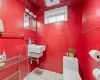 Half bath featuring toilet, tile walls, crown molding, and tile patterned floors