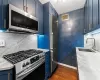 Kitchen with stainless steel appliances, a sink, visible vents, and blue cabinets