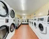 Common laundry area with dark tile patterned flooring, stacked washer and clothes dryer, and separate washer and dryer