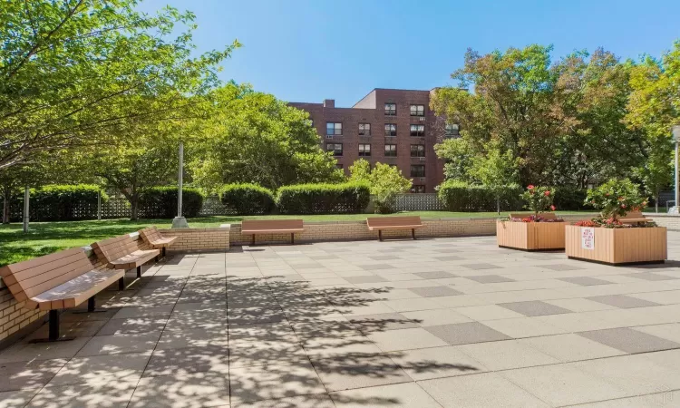 View of property's community with a lawn, a patio area, and fence