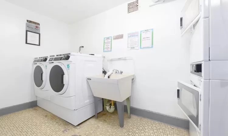 Common laundry area featuring baseboards, visible vents, separate washer and dryer, and light tile patterned flooring