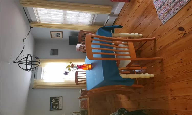 Dining space featuring an inviting chandelier, a baseboard radiator, light wood-style flooring, and a healthy amount of sunlight