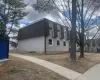 View of side of home featuring a shingled roof and mansard roof