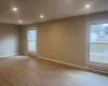 Empty room with a baseboard heating unit, recessed lighting, and wood finished floors