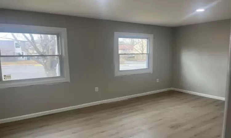 Empty room with light wood finished floors, baseboards, and recessed lighting