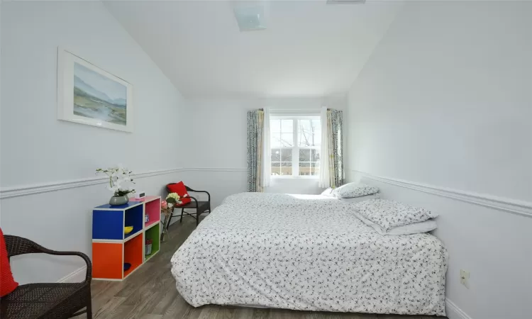 Bedroom with vaulted ceiling, wood finished floors